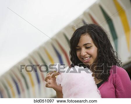 Mixed Race girl eating cotton candy View Large Photo Image Stock Photo - Mixed Race girl eating cotton candy. Fotosearch