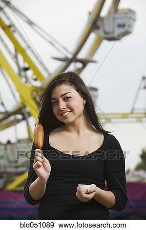 Stock Photo - Mixed Race girl holding corn dog. Fotosearch