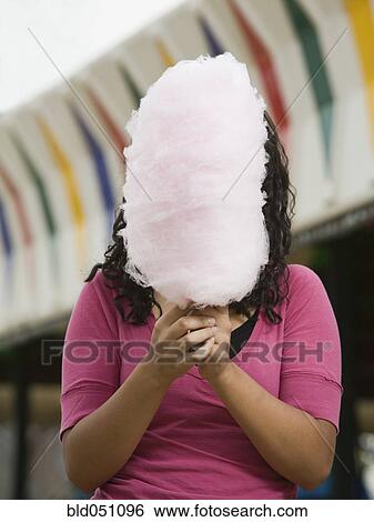 Mixed Race girl holding cotton candy in front of face View Large Photo Image Stock Photograph - Mixed Race girl holding cotton candy in front of face. Fotosearch