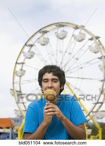 Mixed Race teenaged boy eating candied apple View Large Photo Image Picture - Mixed Race teenaged boy eating candied apple. Fotosearch