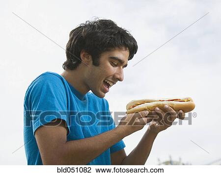 Mixed Race teenaged boy eating hot dog View Large Photo Image Stock Image - Mixed Race teenaged boy eating hot dog. Fotosearch