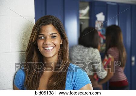 Stock Image - Mixed Race teenaged girl in front of school lockers. Fotosearch