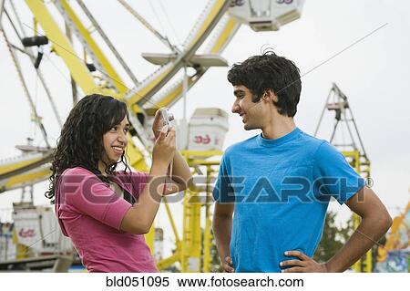Mixed Race teenaged girl taking photograph of boyfriend View Large Photo Image Stock Photography - Mixed Race teenaged girl taking photograph of boyfriend. Fotosearch