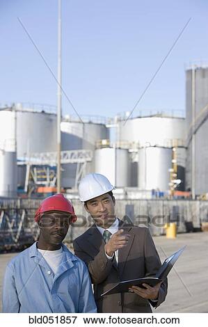 Stock Photo - Multi-ethnic businessman and construction worker wearing hardhats. Fotosearch