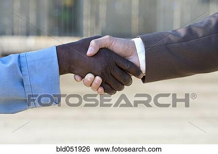 Multi-ethnic businessman and construction worker shaking hands View Large Photo Image Stock Photograph - Multi-ethnic businessman and construction worker shaking hands. Fotosearch