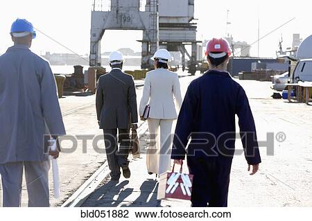 Multi-ethnic businesspeople and construction workers walking View Large Photo Image Stock Image - Multi-ethnic businesspeople and construction workers walking. Fotosearch
