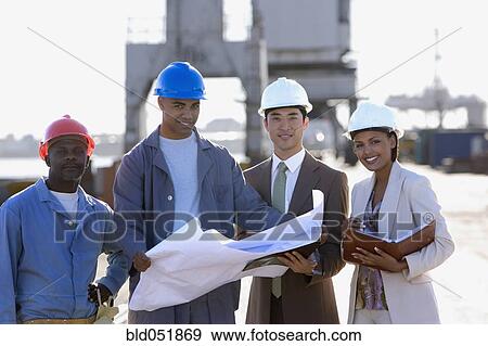 Multi-ethnic businesspeople and construction workers with blueprints View Large Photo Image Stock Photo - Multi-ethnic businesspeople and construction workers with blueprints. Fotosearch