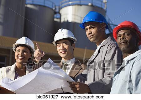 Multi-ethnic businesspeople and construction workers wearing hardhats View Large Photo Image Stock Photo - Multi-ethnic businesspeople and construction workers wearing hardhats. Fotosearch