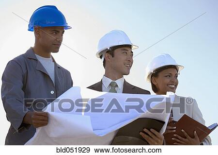Stock Photo - Multi-ethnic businesspeople and construction worker with blueprints. Fotosearch