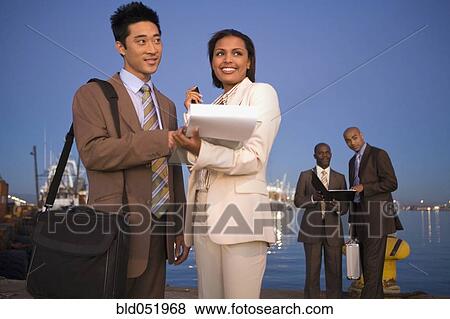 Multi-ethnic businesspeople on commercial pier View Large Photo Image Stock Photo - Multi-ethnic businesspeople on commercial pier. Fotosearch