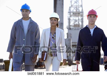 Multi-ethnic businesswoman and construction workers walking View Large Photo Image Stock Image - Multi-ethnic businesswoman and construction workers walking. Fotosearch