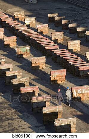 Stock Image - Multi-ethnic construction workers walking on pier. Fotosearch
