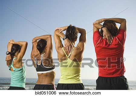 Multi-ethnic female runners stretching at beach View Large Photo Image Stock Photograph - Multi-ethnic female runners stretching at beach. Fotosearch