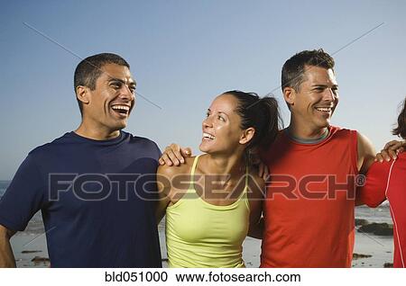Stock Image - Multi-ethnic friends hugging. Fotosearch