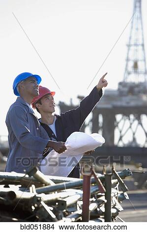 Picture - Multi-ethnic male construction workers pointing. Fotosearch