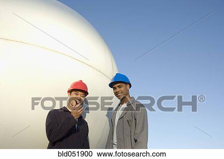 Stock Image - Multi-ethnic male construction workers with walkie talkie. Fotosearch