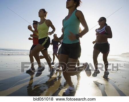 Multi-ethnic runners racing at beach View Large Photo Image Stock Photo - Multi-ethnic runners racing at beach. Fotosearch