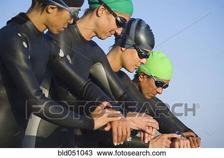 Multi-ethnic swimmers checking watches View Large Photo Image Stock Image - Multi-ethnic swimmers checking watches. Fotosearch