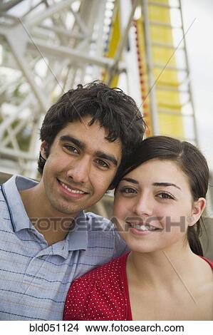 Picture - Multi-ethnic teenaged couple on carnival ride. Fotosearch
