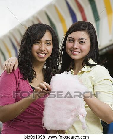 Stock Photo - Multi-ethnic teenaged girls eating cotton candy. Fotosearch