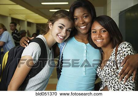 Multi-ethnic teenaged girls hugging in school hallway View Large Photo Image Stock Image - Multi-ethnic teenaged girls hugging in school hallway. Fotosearch
