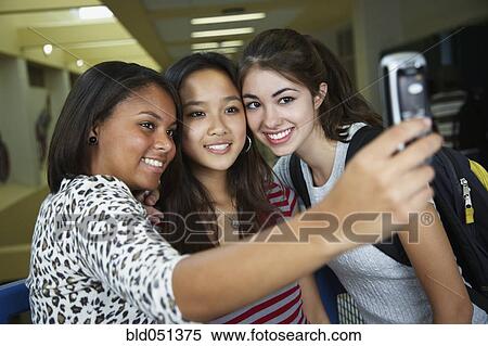 Multi-ethnic teenaged girls taking own photograph View Large Photo Image Stock Photography - Multi-ethnic teenaged girls taking own photograph. Fotosearch