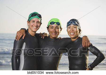 Picture - Multi-ethnic women wearing wetsuits and goggles. Fotosearch