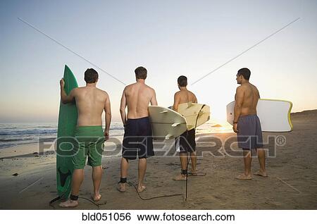 Rear view of multi-ethnic surfers View Large Photo Image Stock Photograph - Rear view of multi-ethnic surfers. Fotosearch
