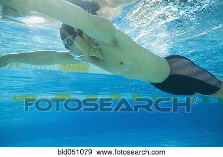 Stock Photo - Underwater shot of Asian man swimming. Fotosearch