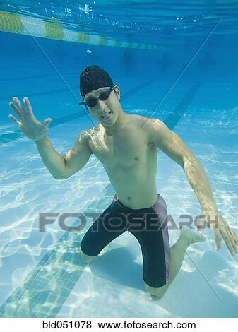 Underwater shot of Asian man waving View Large Photo Image Stock Photo - Underwater shot of Asian man waving. Fotosearch