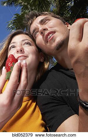Young couple holding strawberries View Large Photo Image Stock Photo - Young couple holding strawberries. Fotosearch