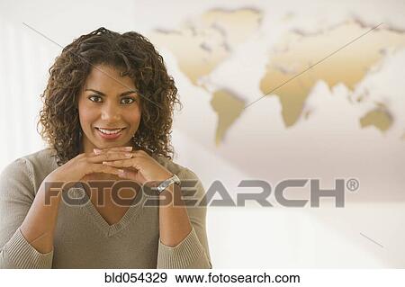 Stock Photo - African businesswoman in front of world map. Fotosearch