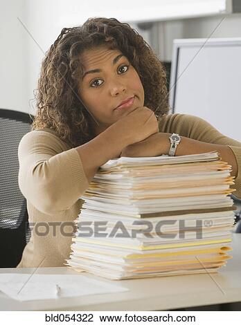 African businesswoman leaning on stack of paperwork View Large Photo Image Stock Image - African businesswoman leaning on stack of paperwork. Fotosearch