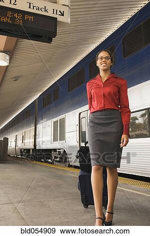 African businesswoman pulling suitcase as train station View Large Photo Image Stock Photo - African businesswoman pulling suitcase as train station. Fotosearch