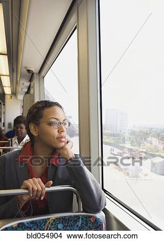 Picture - African businesswoman riding on train. Fotosearch