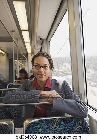 Stock Image - African businesswoman riding on train. Fotosearch