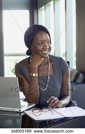 African businesswoman sitting at desk View Large Photo Image Stock Photo - African businesswoman sitting at desk. Fotosearch