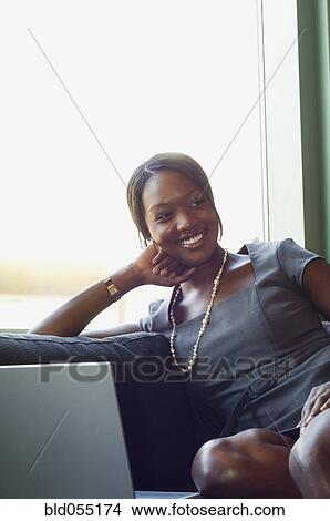 African businesswoman sitting on sofa View Large Photo Image Picture - African businesswoman sitting on sofa. Fotosearch