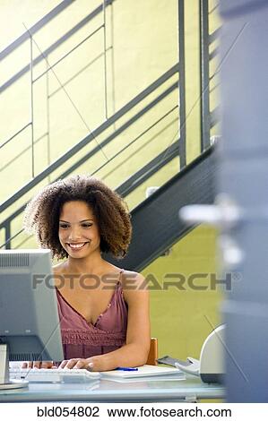 Stock Image - African businesswoman typing on computer. Fotosearch