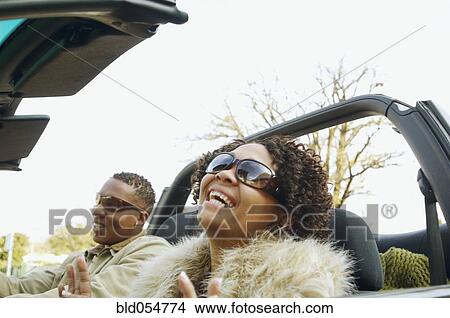 Picture - African couple driving in convertible car. Fotosearch
