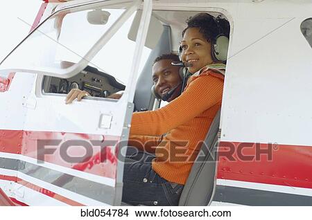 Picture - African couple in cockpit of airplane. Fotosearch