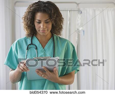 Stock Image - African female doctor looking at chart. Fotosearch