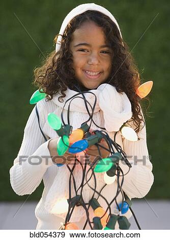 African girl holding Christmas lights View Large Photo Image Stock Photo - African girl holding Christmas lights. Fotosearch