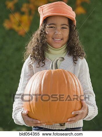 African girl holding pumpkin View Large Photo Image Stock Photography - African girl holding pumpkin. Fotosearch