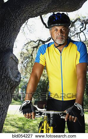 African male cyclist next to bicycle View Large Photo Image Stock Photo - African male cyclist next to bicycle. Fotosearch