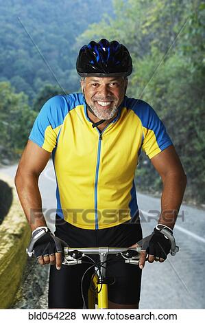 Stock Photo - African male cyclist riding bicycle. Fotosearch