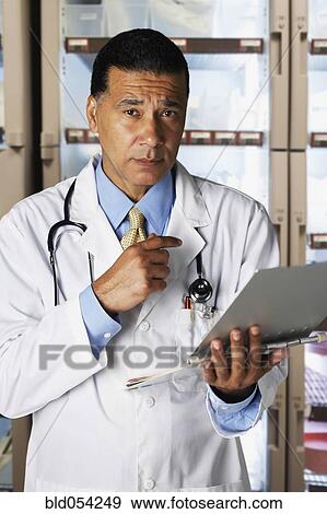 Stock Photo - African male doctor holding chart. Fotosearch