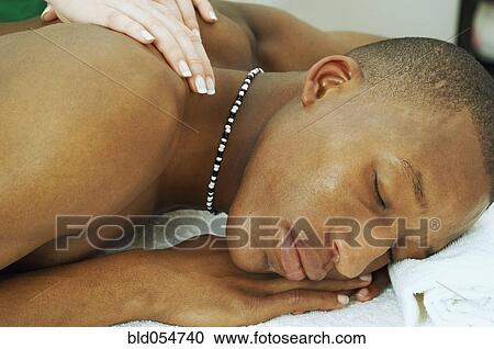 Stock Image - African man receiving massage. Fotosearch