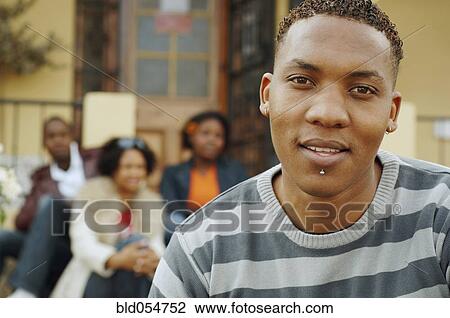 Stock Image - African man with friends in background. Fotosearch