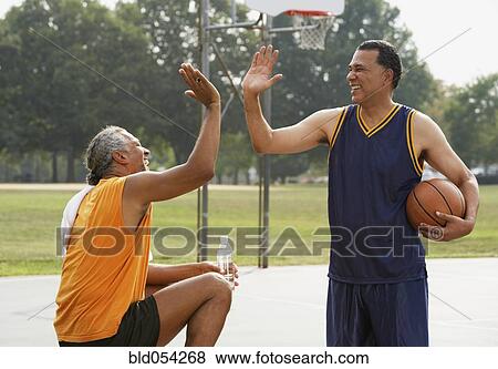 African men high-fiving on basketball court View Large Photo Image Stock Photo - African men high-fiving on basketball court. Fotosearch